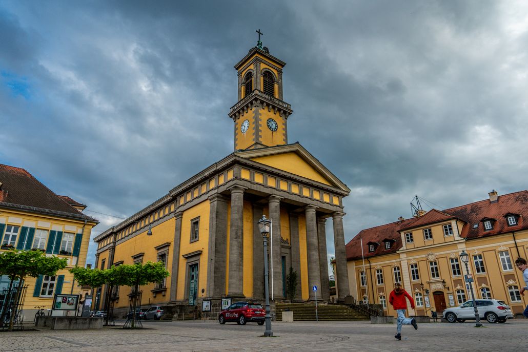 Captivating view of St. Ludwig Church in Ansbach with dramatic clouds overhead, showcasing classic architecture.
