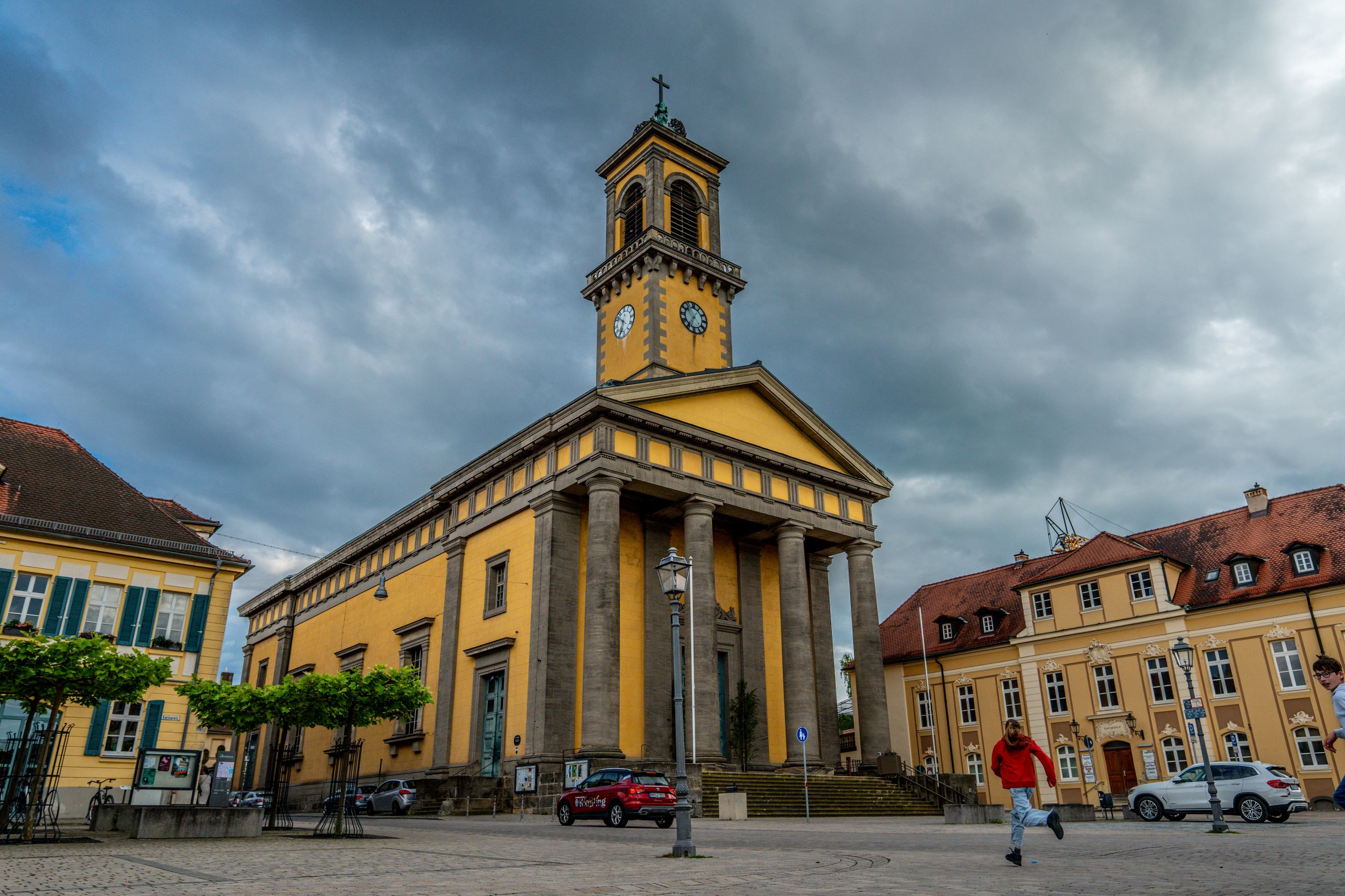 Captivating view of St. Ludwig Church in Ansbach with dramatic clouds overhead, showcasing classic architecture.